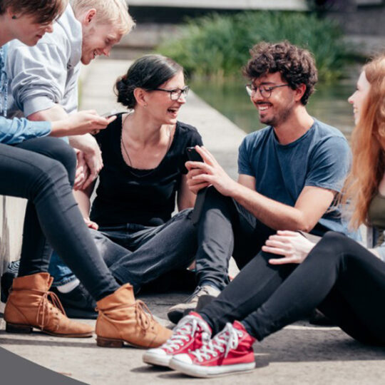 Studierende mit Smartphone im Studierendenwerk Düsseldorf